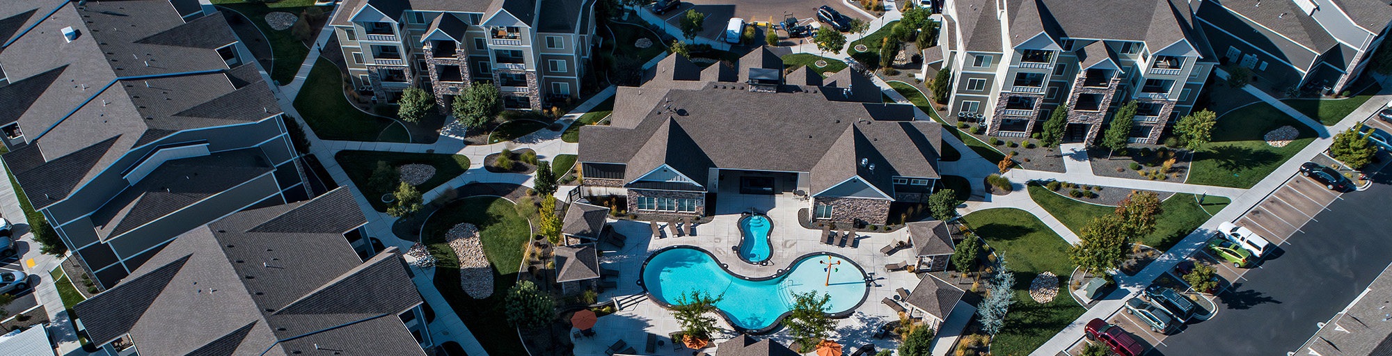 A photo of a multi-family campus from the air, with a swimming pool